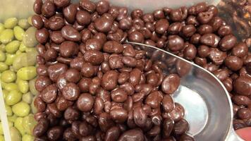 chocolate covered nuts covered in chocolate, rotation in circle. Nuts in chocolate, Turning. chocolate background. Chocolate coated nut video
