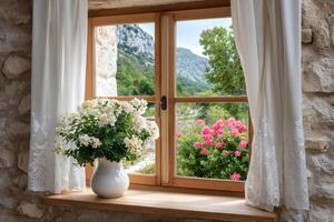 White flowers in a vase sitting on a window sill overlooking a beautiful valley photo