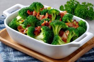 Delicious cooked broccoli with crispy bacon bits in white ceramic bowl photo