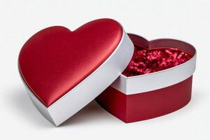 Red heart shaped gift box open showing red shredded paper filling photo