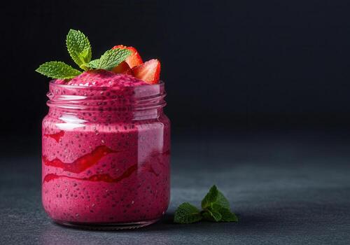 A delicious berry smoothie in a jar, garnished with mint and strawberries. photo