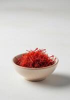 Close-up of saffron threads in a small ceramic bowl. photo