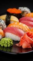 A colorful array of fresh sushi served on a dark plate photo