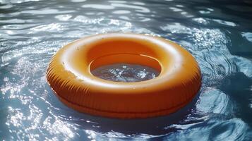 An orange inflatable ring floating in a pool photo