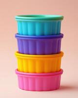 A stack of colorful plastic bowls on a pink background photo