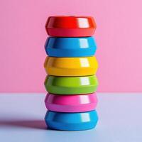 A stack of colorful plastic rings on a pink background photo