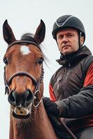A man wearing a helmet and riding a horse photo