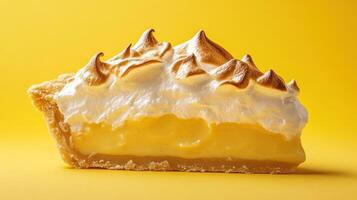 Lemon meringue pie slice on yellow backdrop photo
