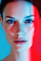 Female model with striking blue eyes illuminated by red and blue lighting, showcasing a captivating expression against a soft gradient background, emphasizing beauty and artistry photo