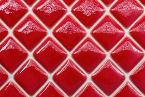 Shiny red rhombus ceramic tiles creating a vibrant wall covering photo