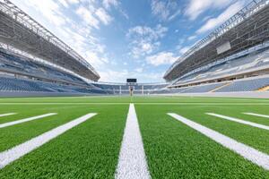 Wide-angle view of empty football stadium with lush green field and blue sky photo