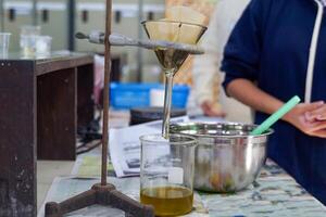 Experiment to separate mixed substances by pouring substances into a separator funnel through filter paper. photo
