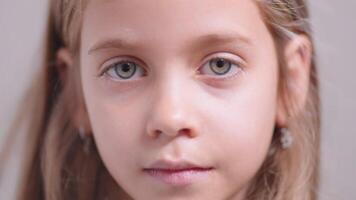 Closeup portrait of little girl looking at camera with calm expression video
