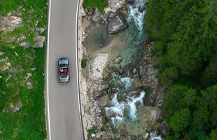 Drive Along a Scenic River With Lush Greenery in the Background During Daylight Hours photo