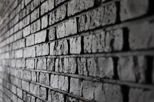 Texture and shadows of a black brick wall in an indoor setting during daylight photo