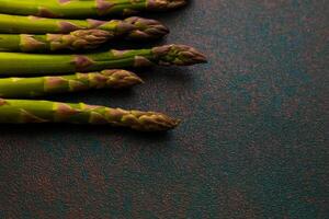 Fresh asparagus arranged on a textured surface ready for cooking or garnishing dishes photo