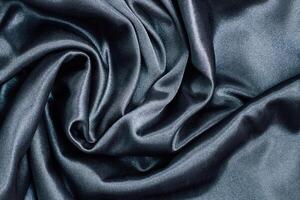 Luxurious dark silk fabric draped elegantly with smooth textures for fashion applications photo