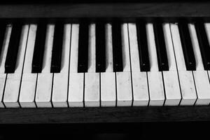 Detailed view of piano keys showcasing black and white keys with worn textures in a musical setting photo