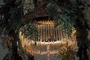 Elegant chandelier adorned with greenery creates an enchanting atmosphere in a modern space photo