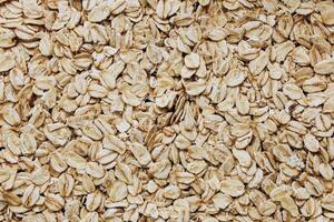 Oats spread across a surface highlighting their texture and natural color variations photo