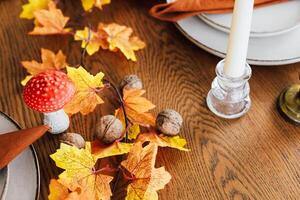 Autumn table setting with leaves mushrooms and candles for seasonal gathering photo