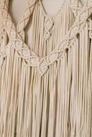 Macrame wall hanging displaying intricate patterns and textures in a light beige color photo