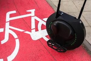 Modern unicycle on bike path in urban setting during daylight photo