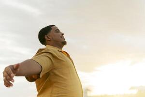Tourist enjoying freedom with open arms under sunset sky photo