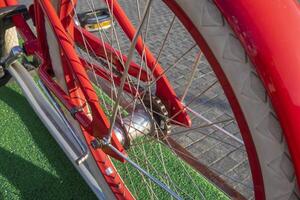 Wheel of red bicycle closeup. Image shows details of spokes and trasmission system. photo