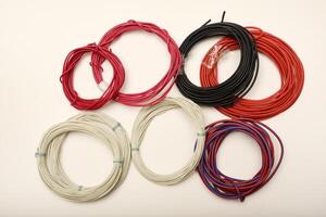 Hand holding a bundle of colorful cables. Bundles of copper connecting wires in rubber insulation. Multicolored wires. photo