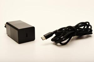 Phone charger with coiled cable on white. A new charger for gadgets with a wire. USB charging with a wire. photo