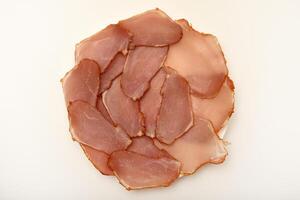 Ham cut into thin slices. Baguette with thinly sliced chicken and pesto photo