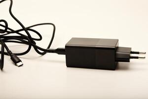 Smartphone charger with cable on white. A new charger for gadgets with a wire. USB charging with a wire. photo