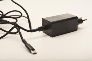 Black charging plug with white cable. A new charger for gadgets with a wire. USB charging with a wire. photo