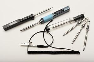 Soldering iron and electronic components. New electronic soldering irons with stingers. Soldering iron with a grounding wire. photo
