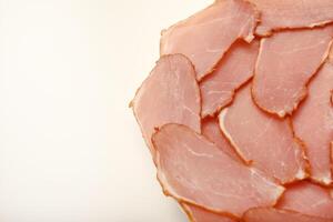 Ham cut into thin slices. Thinly sliced serrano ham on crusty bread photo