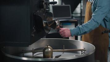 Coffee roaster machine falling beans preparation mixing aroma fresh caffeine on factory unrecognizable man guy barista technologist control roasting fried blend grains production business industry video