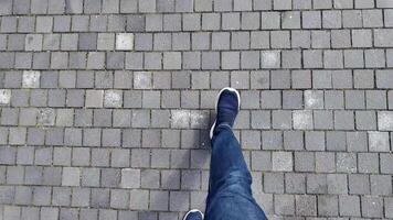 Walking on a cobblestone path in a city area video
