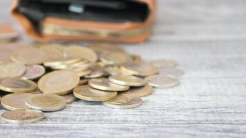 Coins scattered on a wooden surface near a wallet video