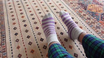 Cozy socks on a colorful rug in a comfy indoor setting video