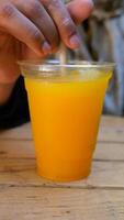 Enjoying refreshing orange drink in a cafe setting video