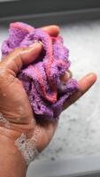 Cleaning a sponge in soapy water at home video