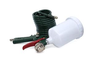 A professional spray gun with a green hose and paint container, isolated on white backdrop. photo