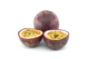 Fresh passion fruits, Passiflora edulis, presenting a whole fruit and two halves showing the pulp and seeds photo