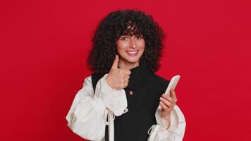 ung kvinna använda sig av smartphone skriver ny posta på webb bläddring sökande missbruk av social nät positiv respons rekommenderar wiFi cellulär förbindelse 5g som visar pekande reklam. röd bakgrund video