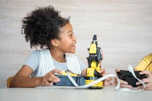 Female Student Focusing on Her STEM Robotics Project, Young Girl Engaged in Robotics Learning and Building, Curious Child Interacting with a Robotic Arm Kit photo