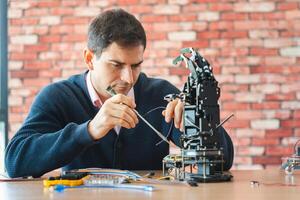 Robotics Engineer Working on Advanced Prosthetic Arm, Man Assembles Bionic Hand Prototype, Scientist Developing Robotic Limb photo