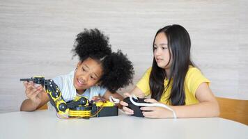 Diverse Kids Building a Robot Arm in a Science Workshop, Young Girls Engaged in Robotics and STEM Learning, Child Girls Exploring Technology and Innovation, Future Engineers photo