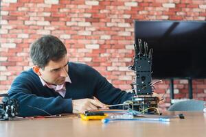 Robotics Engineer Working on Advanced Prosthetic Arm, Man Assembles Bionic Hand Prototype photo
