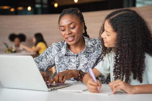 Female Tutor Guiding Student with Homework and Computer, Teacher and Student Collaborating on Computer at Home, Mother and Daughter Studying Together with Laptop photo
